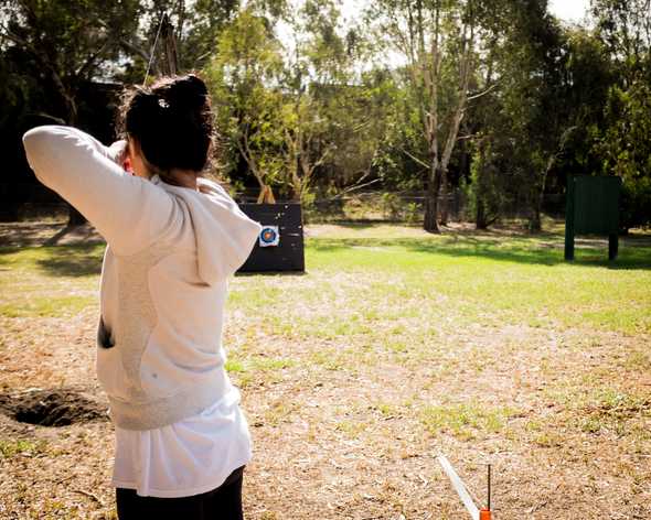 Post-brunch archery adventure: Mia shooing a bow and arrow